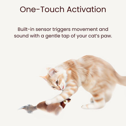 Orange tabby cat playing with bird toy that activates with a single paw tap.